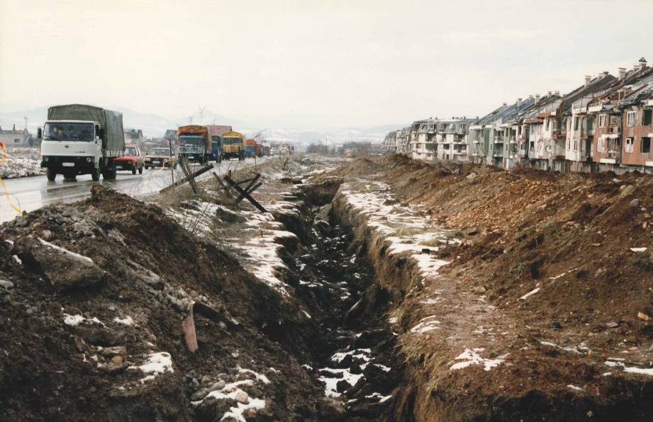 Three parallel lines: traffic carrying the fleeing Bosnian Serbs; a trench for Dobrinja residents to run through on their way in to the city for supplies; and destroyed apartment buildings.